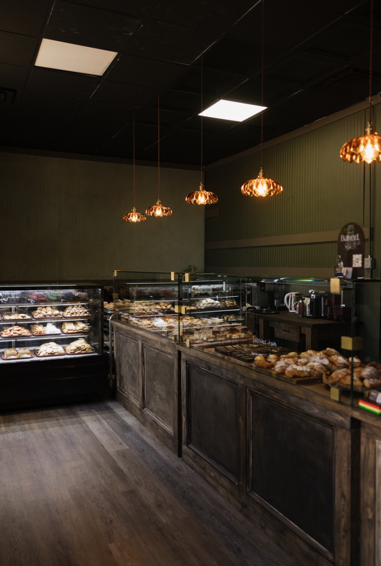 Copper pendant lights over the pastry cases at Baked. By Chelle